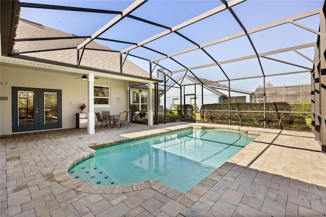 pool with glass enclosure, ceiling fan, a patio, and french doors