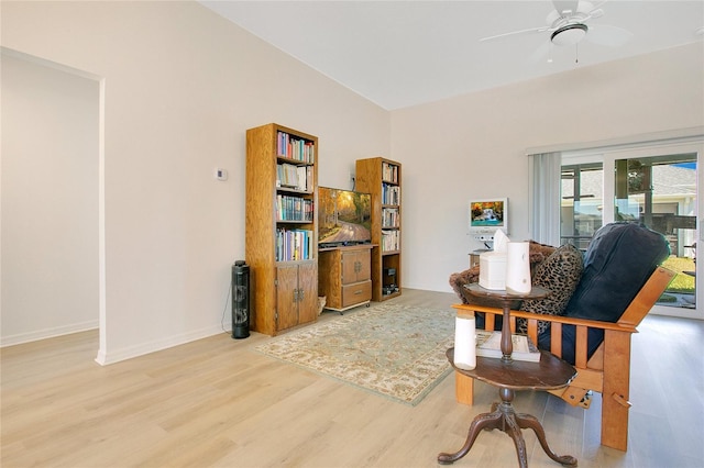 living area featuring wood finished floors, baseboards, and ceiling fan