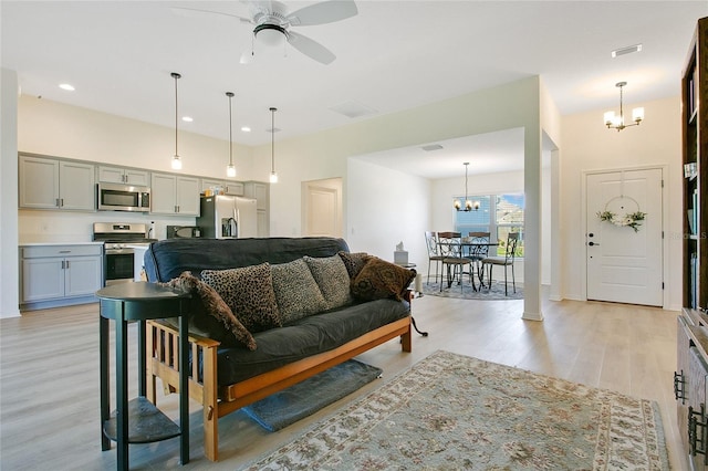 living area with recessed lighting, visible vents, ceiling fan with notable chandelier, and light wood finished floors