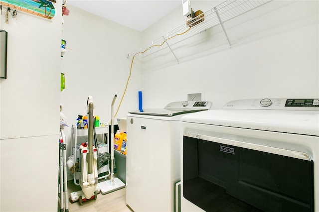 laundry area featuring laundry area, light wood-style flooring, and separate washer and dryer