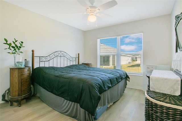 bedroom featuring baseboards, light wood finished floors, and ceiling fan