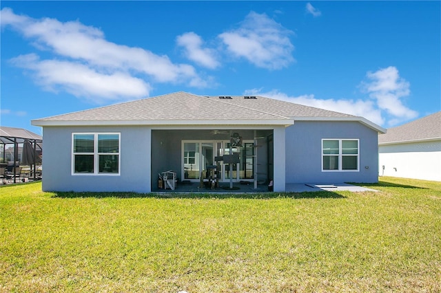 back of property featuring stucco siding, a patio, and a yard