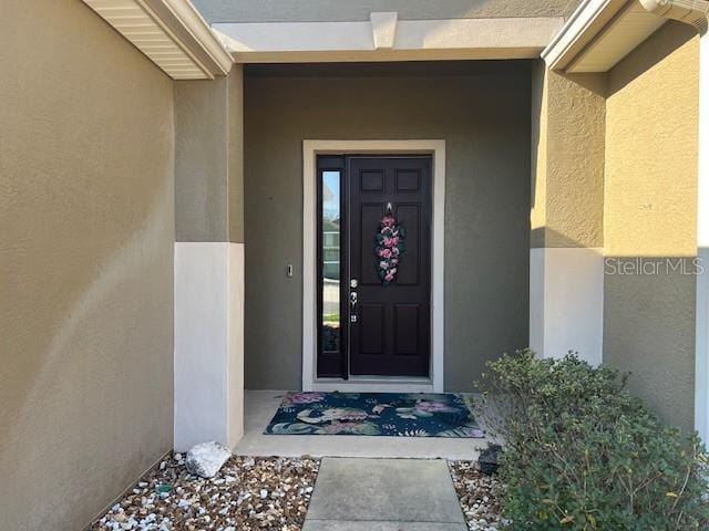 view of exterior entry with stucco siding