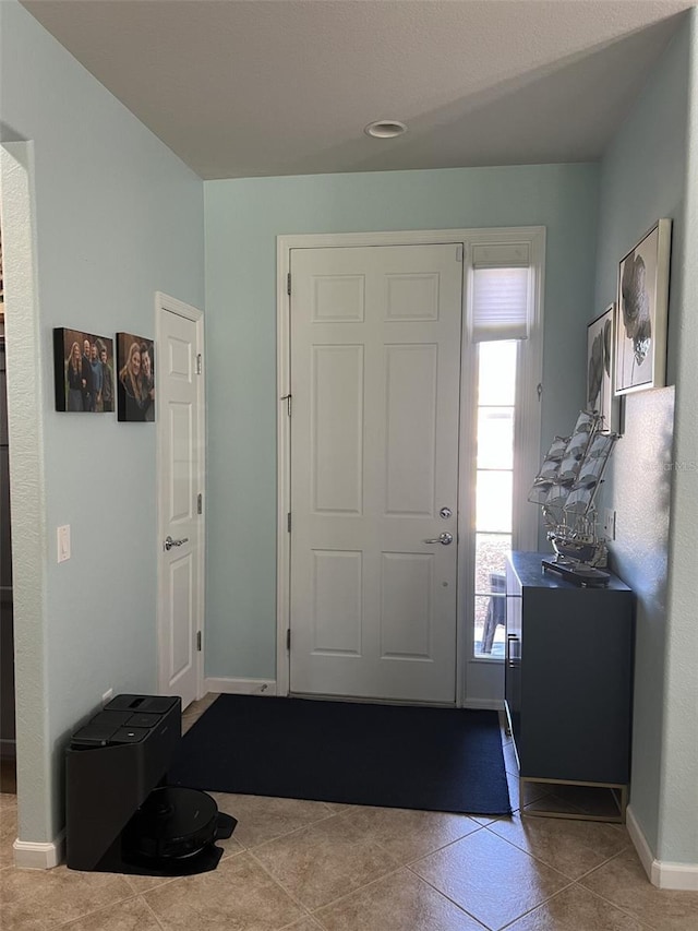 foyer with tile patterned flooring and baseboards