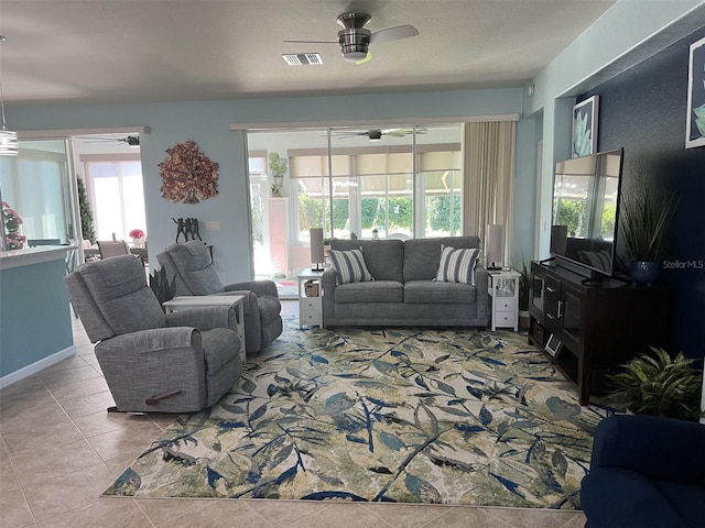 tiled living room with visible vents and a ceiling fan