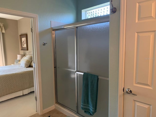 full bathroom featuring a shower stall, baseboards, and connected bathroom