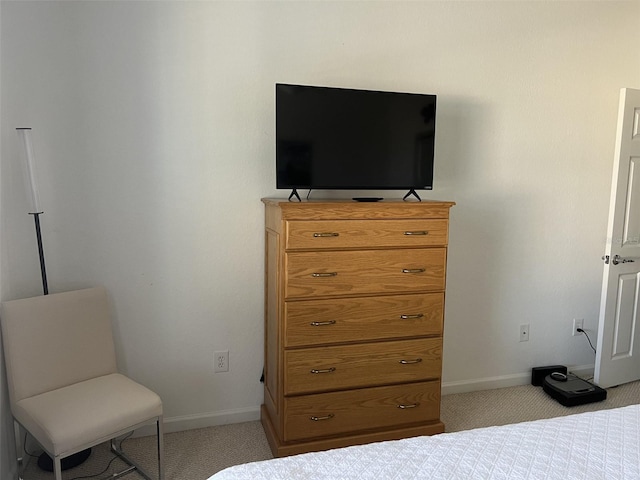 bedroom featuring light colored carpet and baseboards