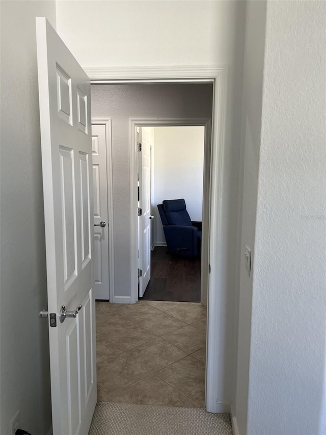 hall featuring dark tile patterned floors