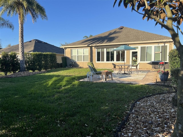 back of property featuring a yard, stucco siding, and a patio