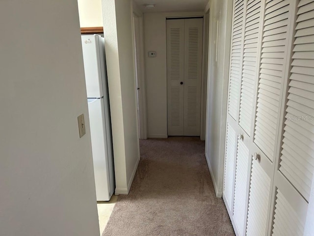 hallway with light carpet and baseboards