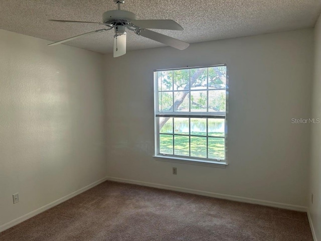 carpeted spare room featuring plenty of natural light, baseboards, and a textured ceiling