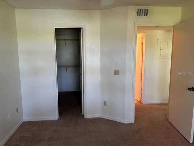 unfurnished bedroom with baseboards, visible vents, a walk in closet, carpet flooring, and a closet