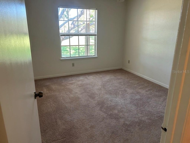 carpeted spare room with baseboards