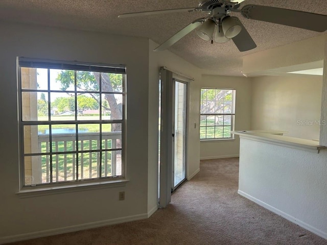 unfurnished room with carpet floors, a textured ceiling, and baseboards