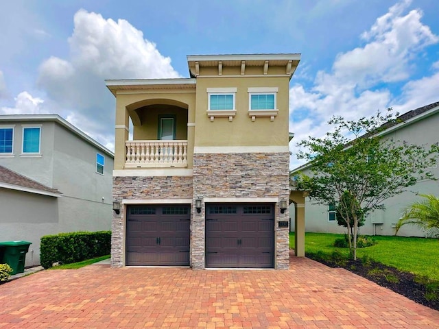 view of front of property featuring decorative driveway, stone siding, and stucco siding