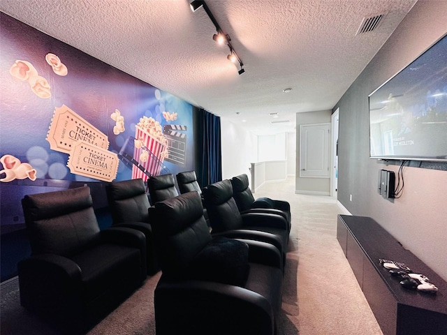 carpeted home theater with rail lighting, visible vents, a textured ceiling, and baseboards