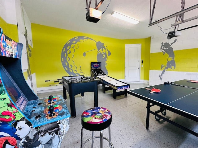playroom featuring a garage, a textured ceiling, and speckled floor