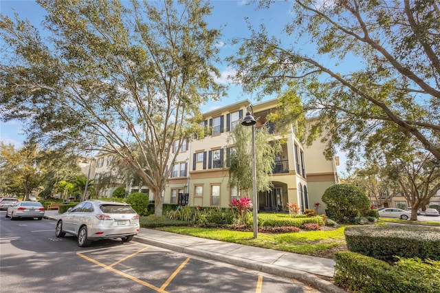 view of building exterior featuring uncovered parking and a residential view