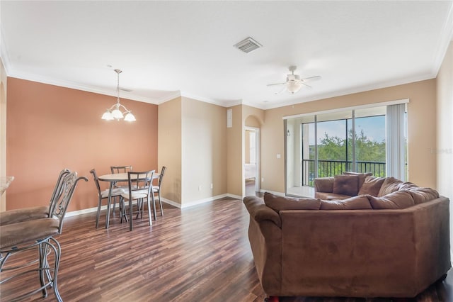 living area with baseboards, visible vents, dark wood finished floors, and ornamental molding