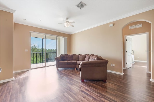 living room featuring arched walkways, dark wood-style flooring, visible vents, and crown molding