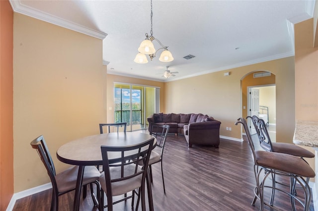 dining space with baseboards, visible vents, arched walkways, dark wood-style floors, and ornamental molding