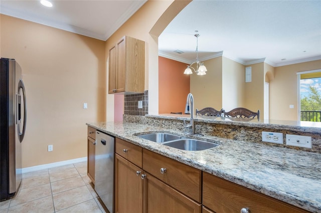 kitchen with light stone counters, light tile patterned flooring, a sink, ornamental molding, and appliances with stainless steel finishes