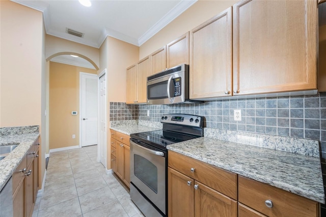 kitchen featuring visible vents, light stone countertops, stainless steel appliances, crown molding, and backsplash