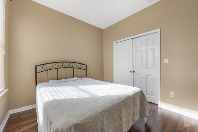 bedroom featuring a closet, baseboards, and wood finished floors