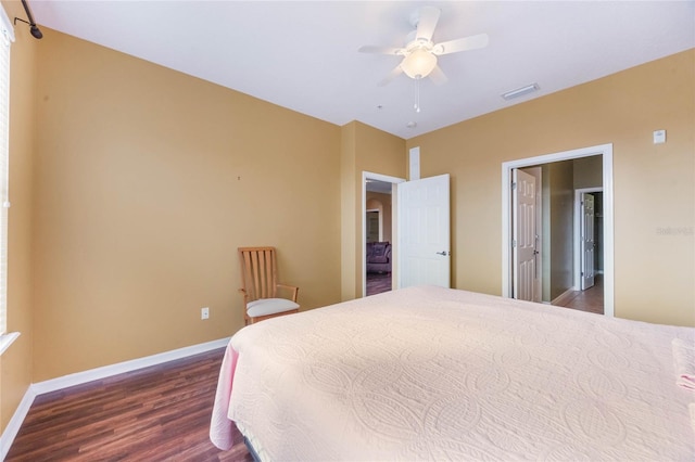 bedroom featuring visible vents, dark wood finished floors, baseboards, and ceiling fan