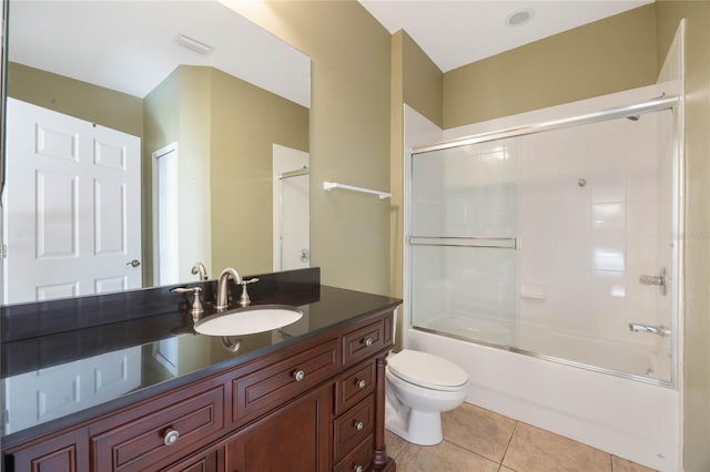 bathroom featuring visible vents, toilet, enclosed tub / shower combo, tile patterned flooring, and vanity