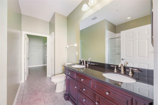 full bathroom with tile patterned flooring, visible vents, a sink, and a shower with door