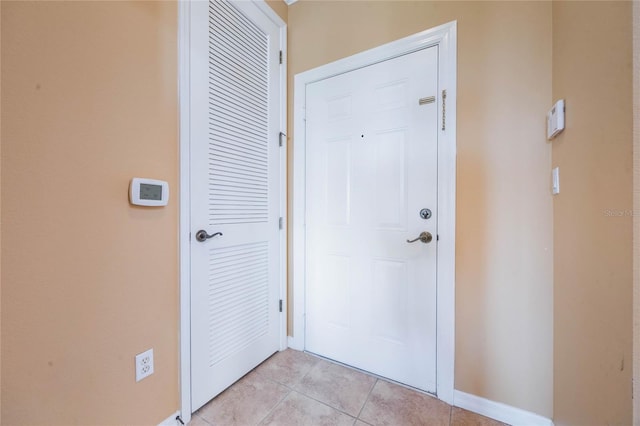 doorway to outside featuring baseboards and light tile patterned floors