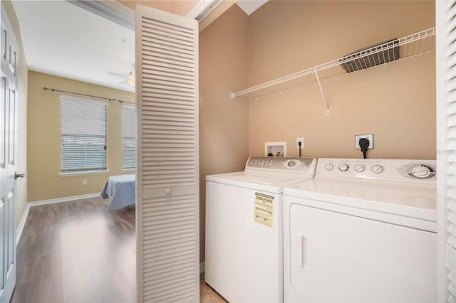 washroom featuring laundry area, a ceiling fan, baseboards, light wood-style floors, and washer and clothes dryer