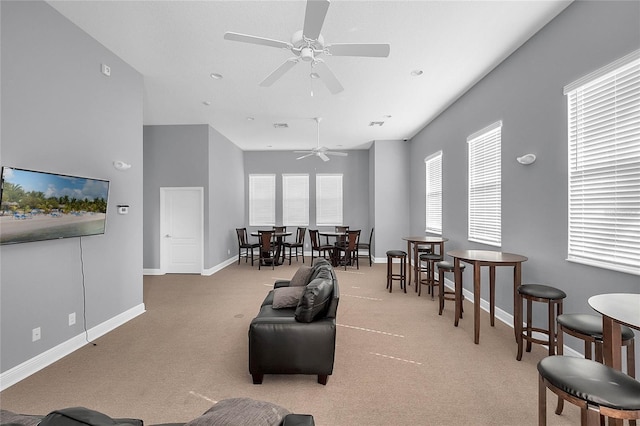 carpeted living room with a ceiling fan and baseboards
