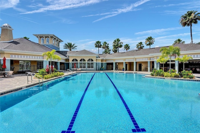 pool with a patio area and fence