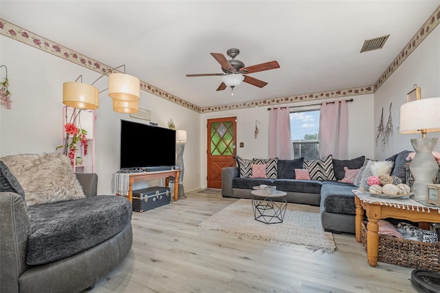 living area with a ceiling fan, wood finished floors, and visible vents