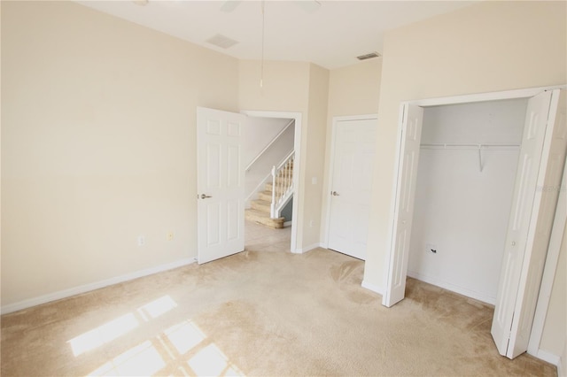 unfurnished bedroom with baseboards, a closet, visible vents, and light colored carpet