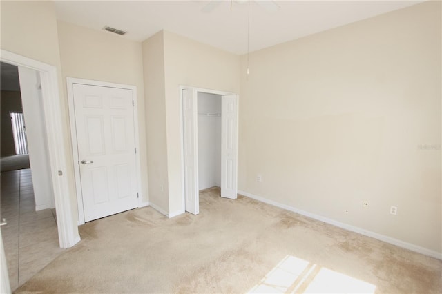 unfurnished bedroom with light colored carpet, a ceiling fan, baseboards, visible vents, and a closet