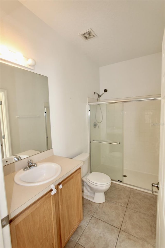 full bath with visible vents, a shower with door, toilet, and tile patterned floors