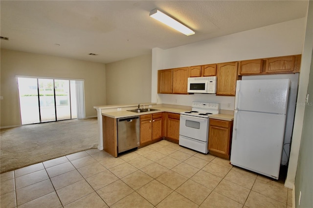 kitchen with light colored carpet, a peninsula, white appliances, a sink, and light countertops