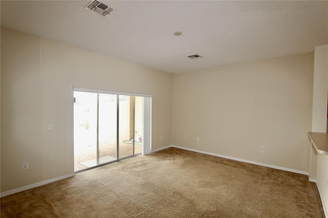 carpeted spare room with visible vents and baseboards