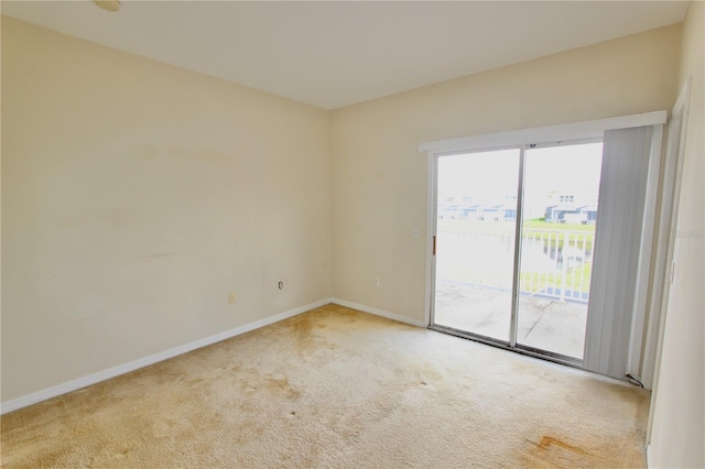 unfurnished room with carpet flooring and baseboards