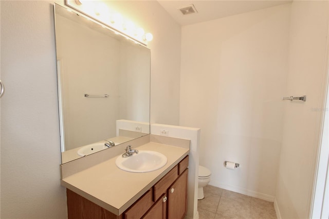 bathroom with toilet, vanity, baseboards, visible vents, and tile patterned floors