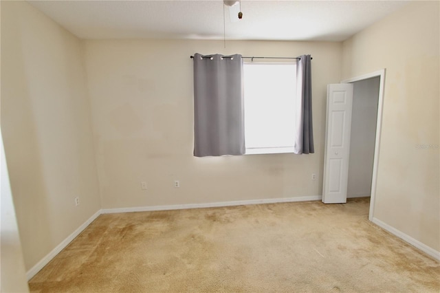 spare room featuring carpet and baseboards