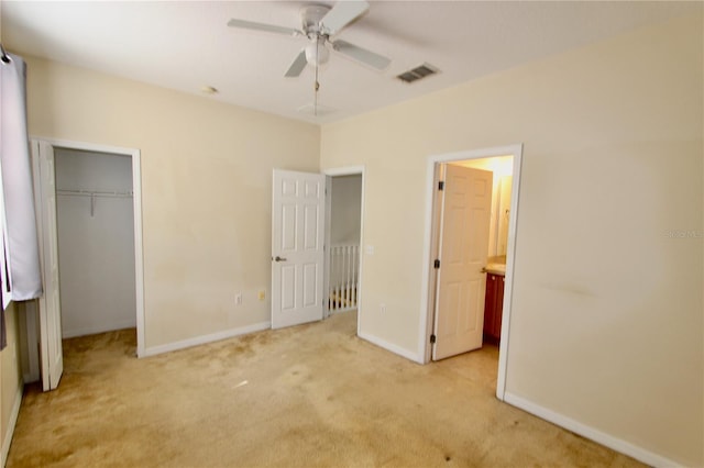 unfurnished bedroom with a closet, light colored carpet, visible vents, a ceiling fan, and baseboards