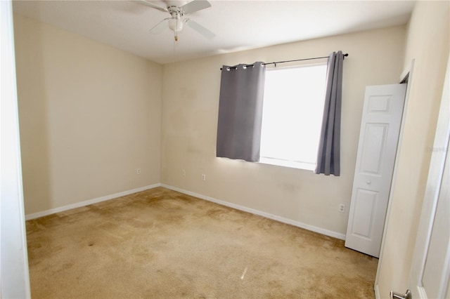 empty room with ceiling fan, carpet, and baseboards