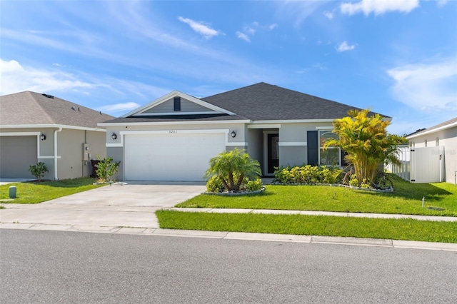 single story home featuring driveway, roof with shingles, a front yard, and stucco siding