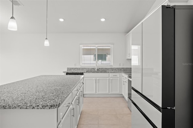 kitchen featuring white cabinets, light stone countertops, stainless steel electric range, a sink, and light tile patterned flooring