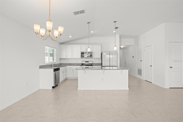 kitchen with visible vents, appliances with stainless steel finishes, a kitchen breakfast bar, a center island, and a sink