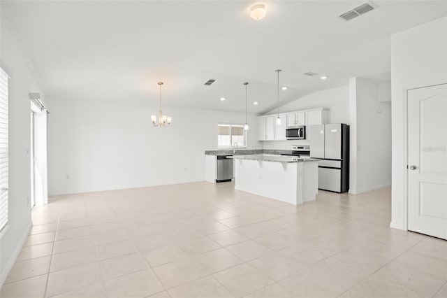 kitchen with visible vents, open floor plan, a center island, stainless steel appliances, and a kitchen bar